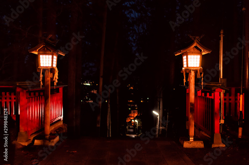 Higashiyama Hakusan Shrine entrance lanterns at night in Takayama, Gifu Prefecture in Japan temple building creepy spooky with view of city