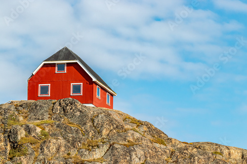 Colorful red wooden house on a hill in Sisimiut, Greenland. photo
