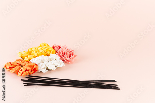 Black incense sticks with white, pink and yellow flowers on pink background