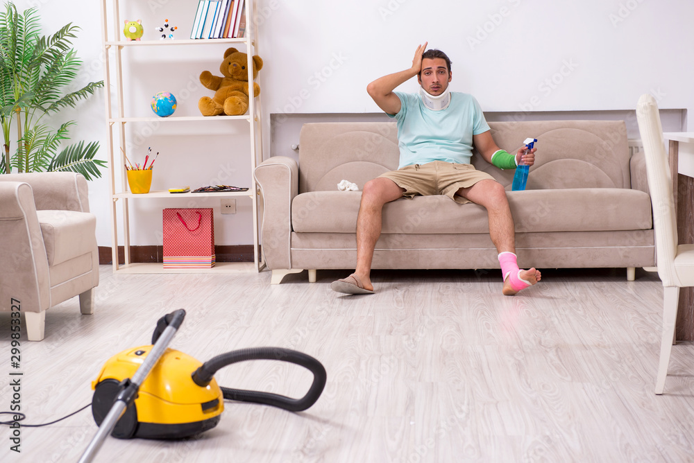 Young injured man cleaning the house Young injured man cleaning the house