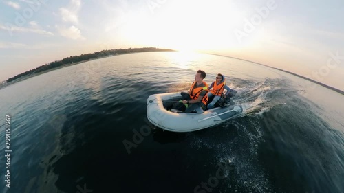 River is being crossed by two men in the inflatable boat photo