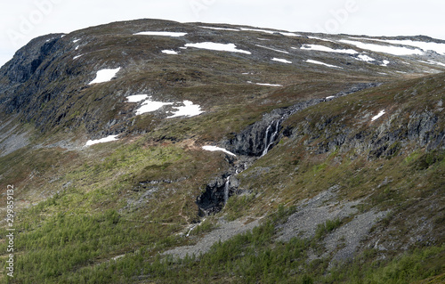 Mountain waterfall in the spring when the snow melts in Lapland, Finland photo