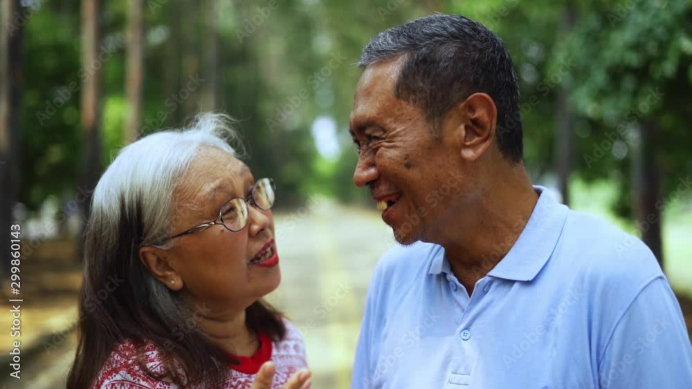 Slow motion of happy elderly couple laughing together at the park on the morning Slow motion of happy elderly couple laughing together at the park on the morning