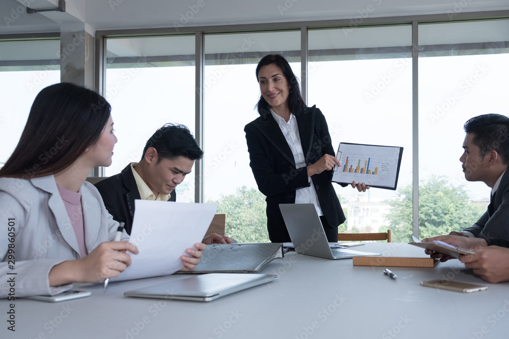 Senior manager presenting graph of sales growth with business team at meeting room. Senior manager presenting graph of sales growth with business team at meeting room.