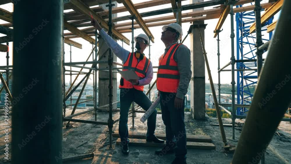 Male engineers are planning constructions among the scaffolding