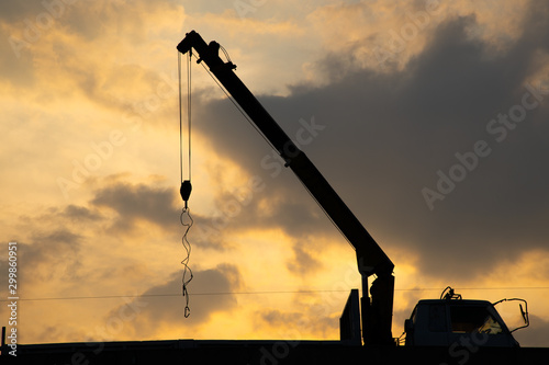 Beautiful sillhuette hydraulic truck crane lines and cloudy sky during sunset background. photo