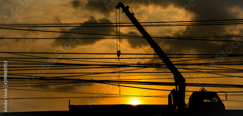 Beautiful sillhuette hydraulic truck crane lines and cloudy sky during sunset background. photo