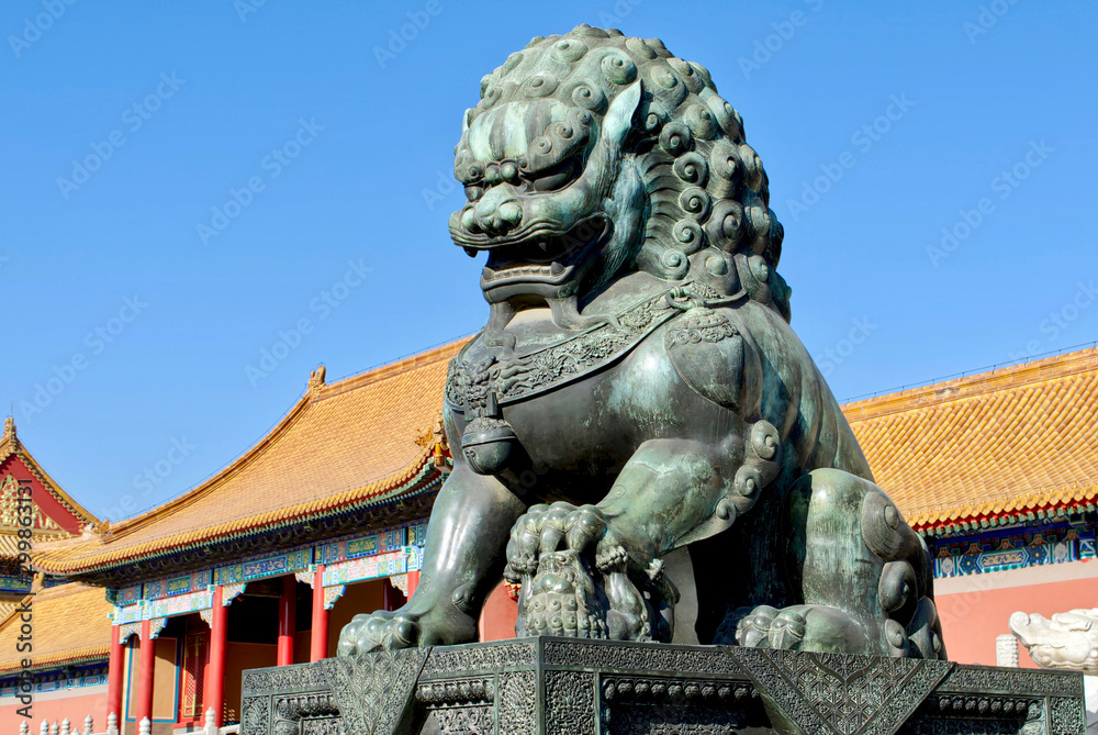 Fototapeta premium bronze lions on the background of the buildings of the imperial palace. The Imperial Palace in Beijing