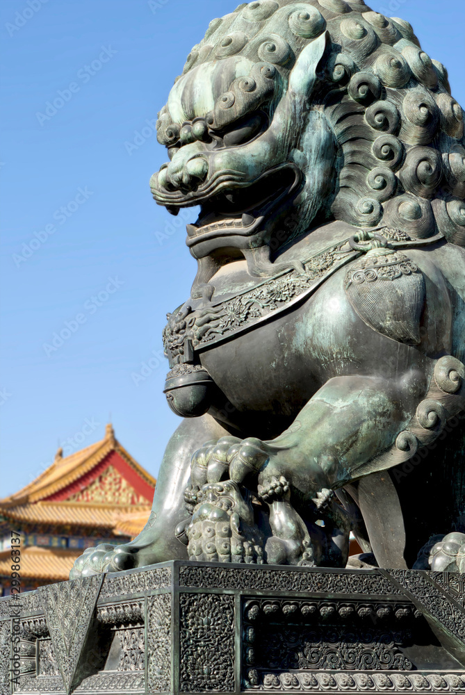 bronze lions on the background of the buildings of the imperial palace. The Imperial Palace in Beijing
