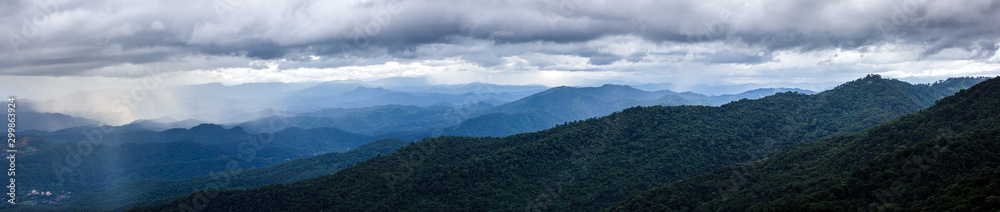 sunset sky with fog and rainy clouds raining over the Majestic mountains landscape