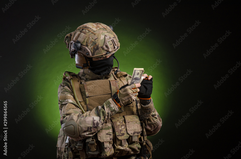 a male soldier in military clothes with a weapon on a dark background with money a male soldier in military clothes with a weapon on a dark background with money