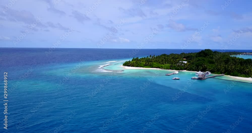 tropical vacation background. Inhabited atoll island with boats anchored on the wooden pier, palms, perfectly clean sea water. copy space tropical vacation background. Inhabited atoll island with boats anchored on the wooden pier, palms, perfectly clean sea water. copy space