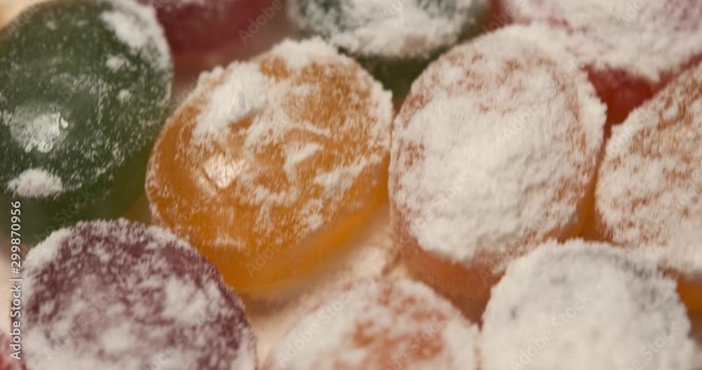 Fast rotation of composition of delicious sweets, lying on rotating platform, sweets fly by camera, lot of sweets in powdered sugar, different colors, different tastes, delicious food, lot of calories