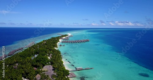 Tropical island on Rasdu Atoll, Kuramathi, with luxury resorts and beautiful white sand beaches in turquoise sea water. Wooden pier with moored boats photo