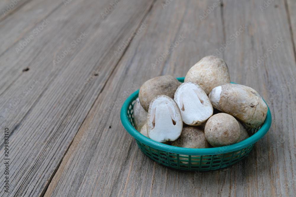Straw mushroom in plastic basket on wooden table Straw mushroom in plastic basket on wooden table