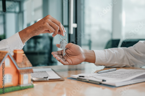 realtor agent giving home key to customer. buying selling renting real estate property