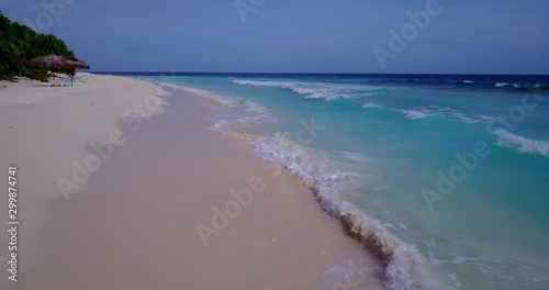 foamy waves splashing paradise white sand beach on caribbean tropical island with preserved nature. Palm forest and turquoise water photo