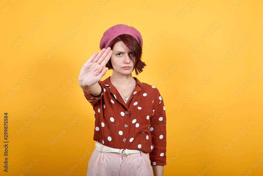 Gorgeous elegant lady on red shirt in white polka dot over isolated background doing stop sing with palm of hand. Warning expression with negative, angry and serious gesture on face. Gorgeous elegant lady on red shirt in white polka dot over isolated background doing stop sing with palm of hand. Warning expression with negative, angry and serious gesture on face.