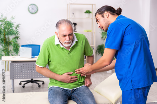 Old man visiting young male doctor gastroenterologist