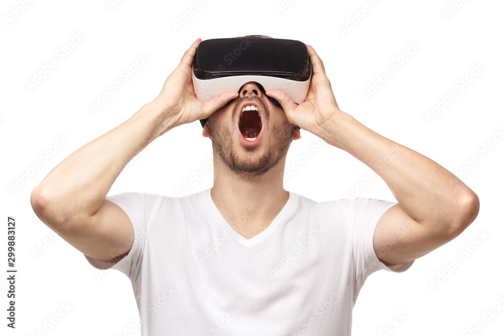 Naklejka premium VR. Close-up studio portrait of screaming young man in virtual reality glasses isolated on white background
