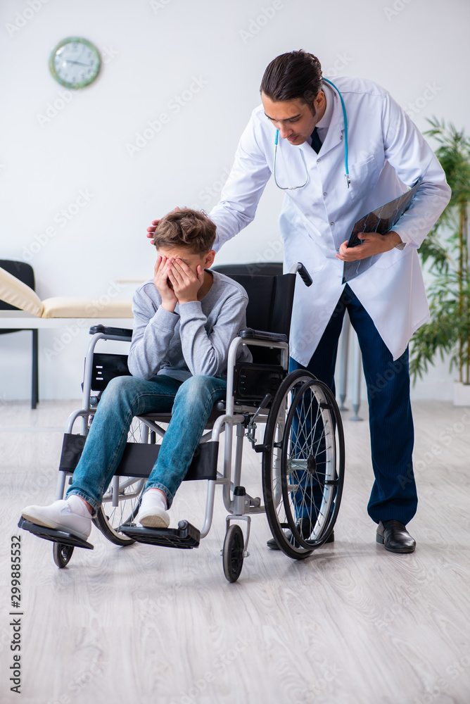 Young male doctor pediatrist and boy in wheel-chair Young male doctor pediatrist and boy in wheel-chair