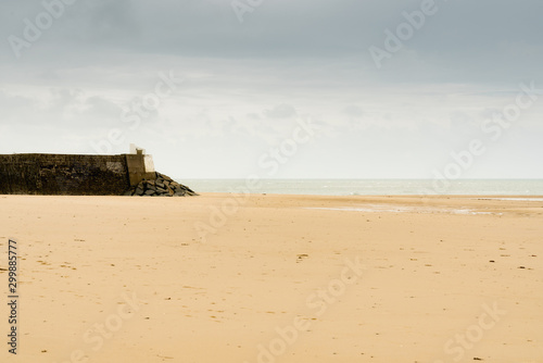 minimalist abstract landscape of stone harbor wall and beach under an overcast sky photo