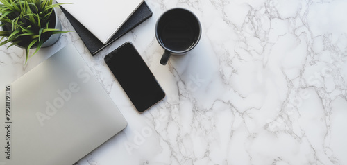 Top view of stylish workspace with laptop computer and office supplies on marble desk