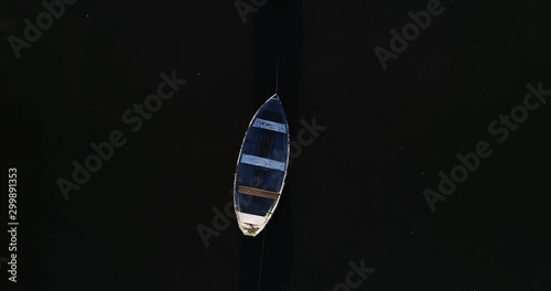 Aerial top view of old rowing boats tied and moored together over black river. White fog moving over black water surface. Mercedes, Rio Negro, Uruguay photo
