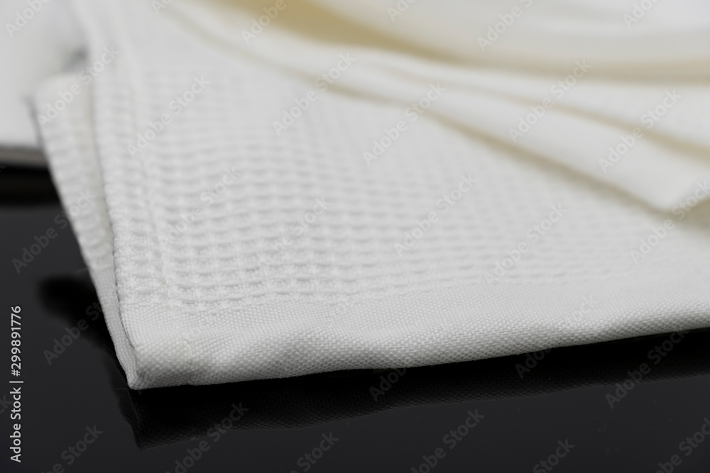 Macro shot texture of folded white towel kitchen fabric isolated on black background Macro shot texture of folded white towel kitchen fabric isolated on black background