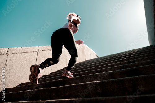 Sporty lady running up the stairs outdoors photo