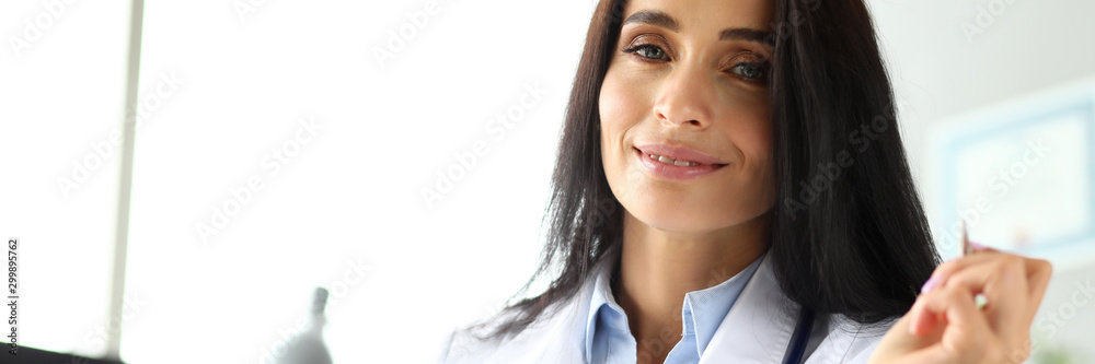 Pretty cheerful GP sitting at worktable writing Pretty cheerful GP sitting at worktable writing