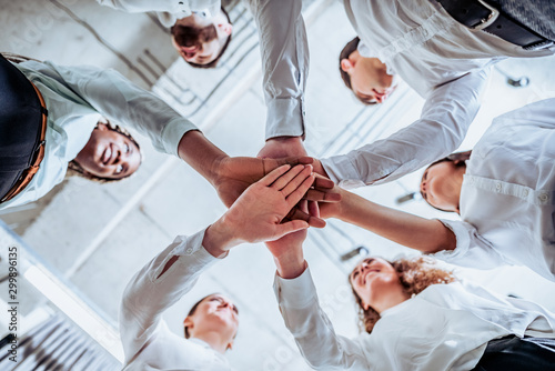 Underneath view, Business teamwork groups people hands, stacked huddle together, unity international. photo