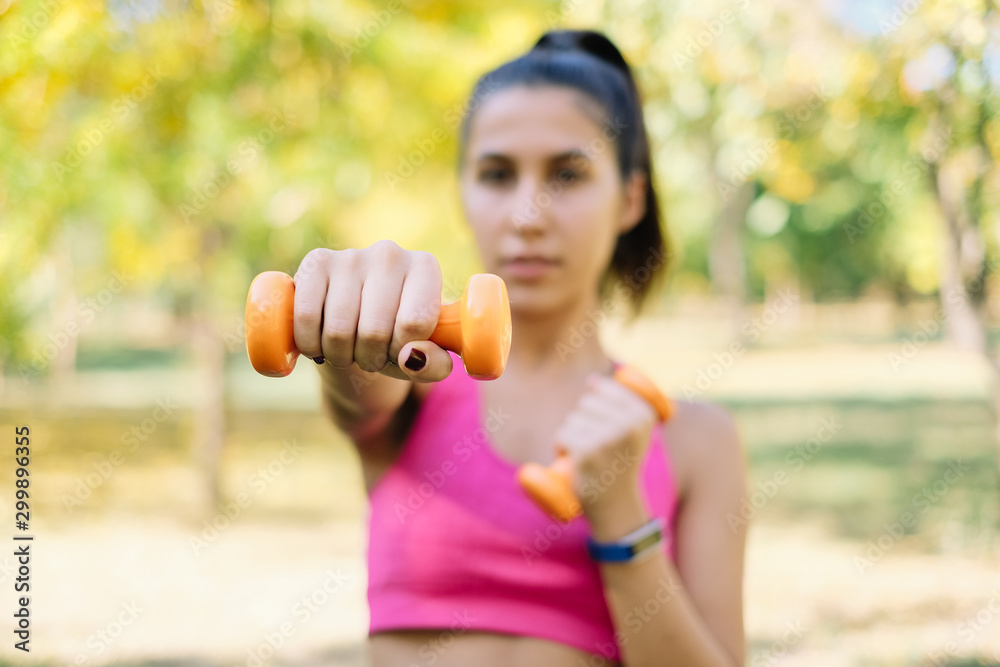 Woman with dumbbells in hands, pushing forward Woman with dumbbells in hands, pushing forward