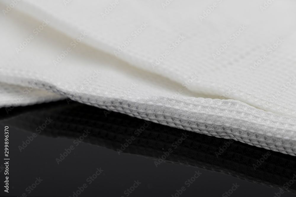 Macro shot texture of folded white towel kitchen fabric isolated on black background Macro shot texture of folded white towel kitchen fabric isolated on black background