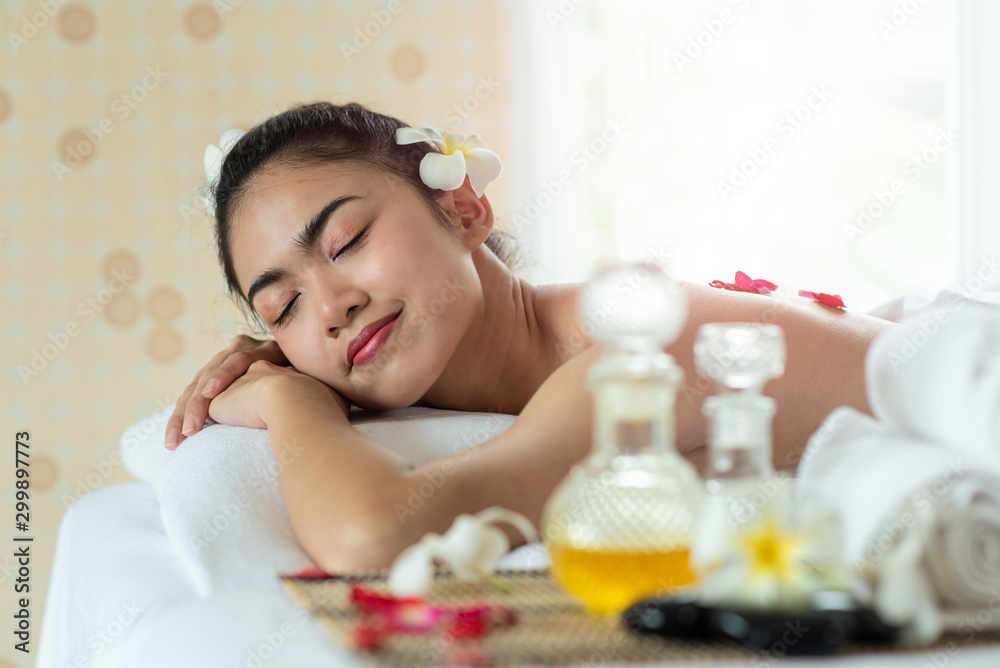 Beautiful Asian woman lying down on massage bed relaxing in spa salon Beautiful Asian woman lying down on massage bed relaxing in spa salon