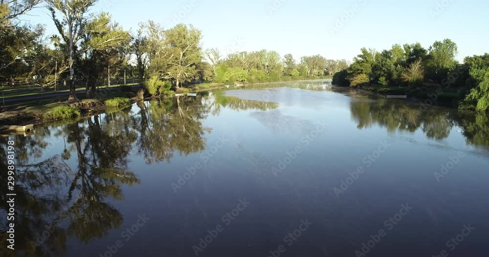 Aerial drone scene flying along river at foggy morning. Reflections, woods. Riparian vegetation. Rio Negro river, Soriano, Mercedes, Uruguay Aerial drone scene flying along river at foggy morning. Reflections, woods. Riparian vegetation. Rio Negro river, Soriano, Mercedes, Uruguay