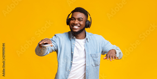 Black guy dancing while listening his favorite music in headphones