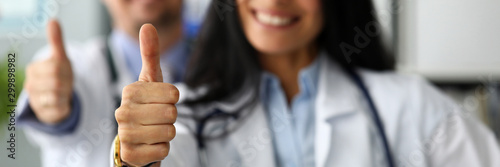 Group of doctors standing in row showing thumb up symbol photo