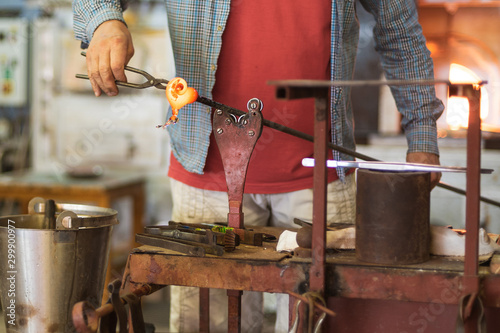 Foto The worker makes a glass ornament in a glassworks