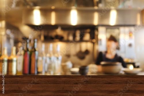Top wood table blur chef cooking in bar restaurant background.For create product display or design key visual layout. Blur bartender serving coffee to customer.