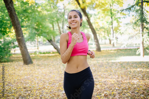 Close up shot of a smiling girl jogging out in the nature
