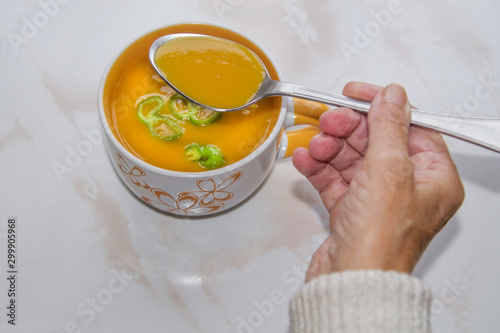 woman eating bowl of soup with spoon