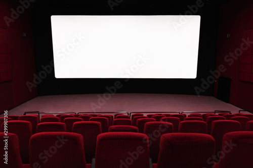 Empty of cinema in blue color with white blank screen. Mockup of hall, no people and auditorium © uv_group