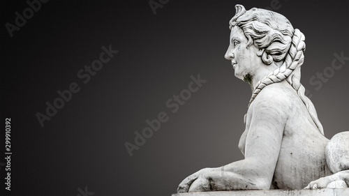 Statue of beautiful Egyptian sphinx, a fusion of a lion and a woman in downtown of Potsdam isolated at smooth even grey background, Germany, portrait, details, paste space
