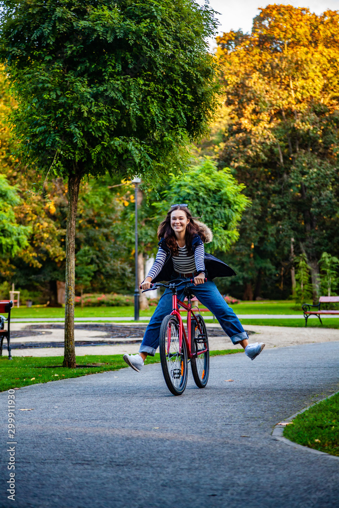Urban biking - woman riding bike in city park Urban biking - woman riding bike in city park