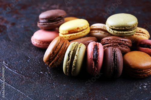 Obraz na plátně Sweet and colourful french macaroons or macaron on dark black background, Dessert