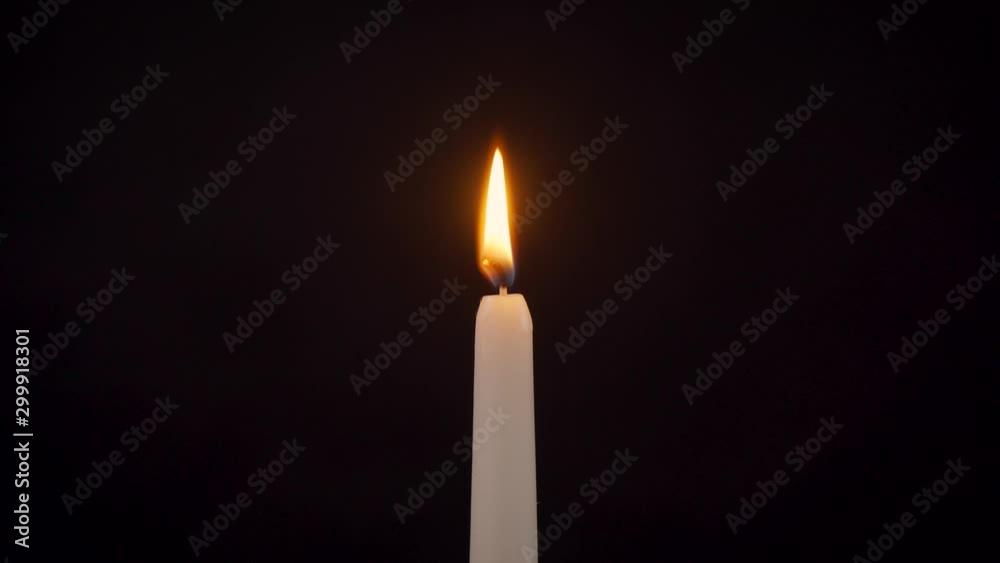 Closeup of an isolated burning candle on a black background Closeup of an isolated burning candle on a black background