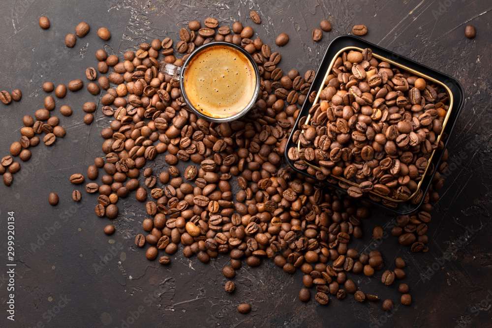Coffee beans in metal jar and espresso in glass cup top view on dark background Coffee beans in metal jar and espresso in glass cup top view on dark background