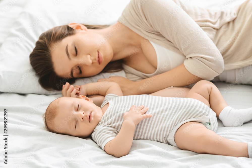 Adorable infant child sleeping with his mom in bedroom Adorable infant child sleeping with his mom in bedroom