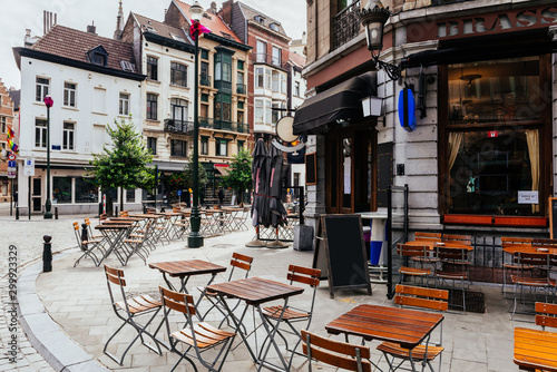 Old street with tables of brasserie in center of Brussels, Belgium. Cozy cityscape of Brussels (Bruxelles). Architecture and landmarks of Brussels.